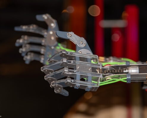 Mechanische Roboterhand mit mehreren beweglichen Fingern und elektrischen Komponenten.