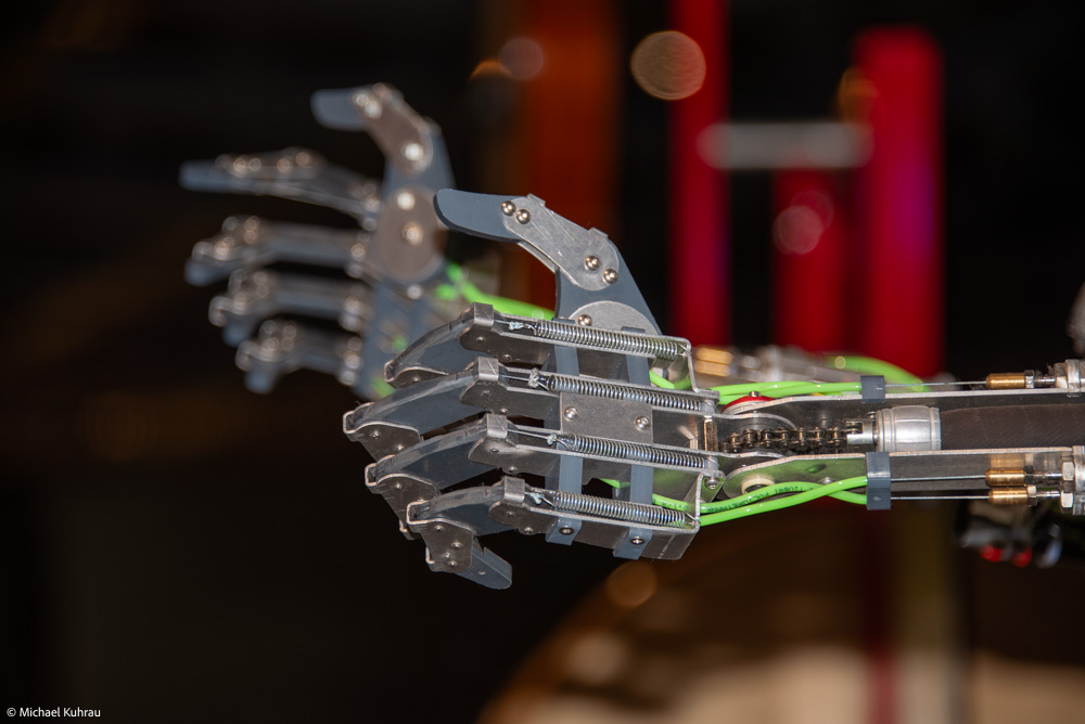 Mechanische Roboterhand mit mehreren beweglichen Fingern und elektrischen Komponenten.