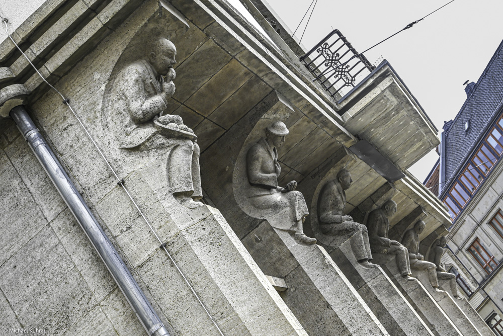 Erfahrungen und Fotos aus Erfurt 27 Erfurt: Stein-Skulpturen am Gebäudeflügel – sitzende Figuren aus Grau-Stein